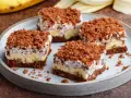 Vier Stücke saftiger Maulwurfkuchen vom Blech mit Bananen und Schokoladenstreuseln auf einem Teller.
