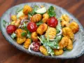 Herzhafter Gnocchi Salat mit Kirschtomaten, Gurken und einem cremigen Dressing.