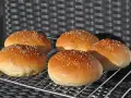 Fünf goldbraune Burgerbrötchen mit Sesam, frisch gebacken nach einem tollen burger buns rezept.