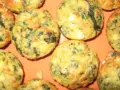 Saftige Spinat Feta Muffins, goldbraun gebacken, mit sichtbaren grünen Spinatstückchen und weißen Feta-Käse-Einlagen.