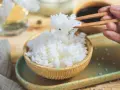 Perfekter sushi reis im reiskocher, dampfend und bereit, mit Stäbchen gegriffen zu werden. Ein Hauch von Asien auf dem Tisch.
