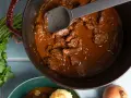 Herzhaftes Gulasch im Gusseisentopf, das beste Gulasch Rezept original Oma. Mit Petersilie und Zwiebeln.