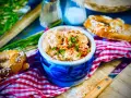 Leckerer Obazda im blauen Steingut-Töpfchen, bestreut mit Schnittlauch und Paprikapulver. Dazu Brezeln und ein Messer. Perfekt für ein Obazda Rezept!
