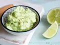 Cremiger Avocado Feta Dip, gewürzt mit Pfeffer, daneben frische Limettenspalten. Perfekt zum Dippen!