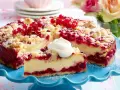 Saftiger Johannisbeerkuchen mit Quark und Streuseln, garniert mit frischen roten Johannisbeeren und einem Klecks Sahne.