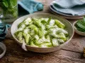 Erfrischender Zucchini-Salat mit Joghurt, Dill und Minze, garniert mit frischen Kräutern. Ein leichter Genuss!