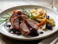 Saftiges Schweinefilet im Speckmantel mit Beerensoße, dazu Rosmarinkartoffeln und bunte Karotten. Ein Klassiker unter den Schweinefilet Rezepten.