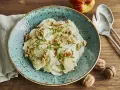 Ein erfrischender rettichsalat mit apfel, garniert mit Walnüssen und Petersilie, auf einem türkisfarbenen Teller.