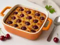 Eine köstliche Kirschpfanne mit Zwieback, goldbraun gebacken und mit saftigen Kirschen belegt. Perfekt für ein süßes Dessert.