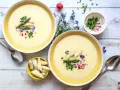 Cremige Spargelsuppe, ein einfaches Rezept für den Frühling. Garniert mit Spargelspitzen, Radieschen und Schnittlauch.