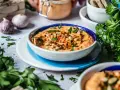 Cremiger Feta Paprika Dip mit Pinienkernen und frischer Petersilie, garniert mit Chiliflocken. Perfekt zum Dippen!