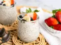 Leckerer Chia Pudding mit Milch, garniert mit Erdbeeren, Bananen und Blaubeeren. Ein gesunder Genuss!