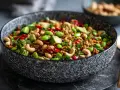Schüssel mit einem bunten, knusprigen Reis-Salat, garniert mit Edamame, Cashewkernen, Avocado und Chili.