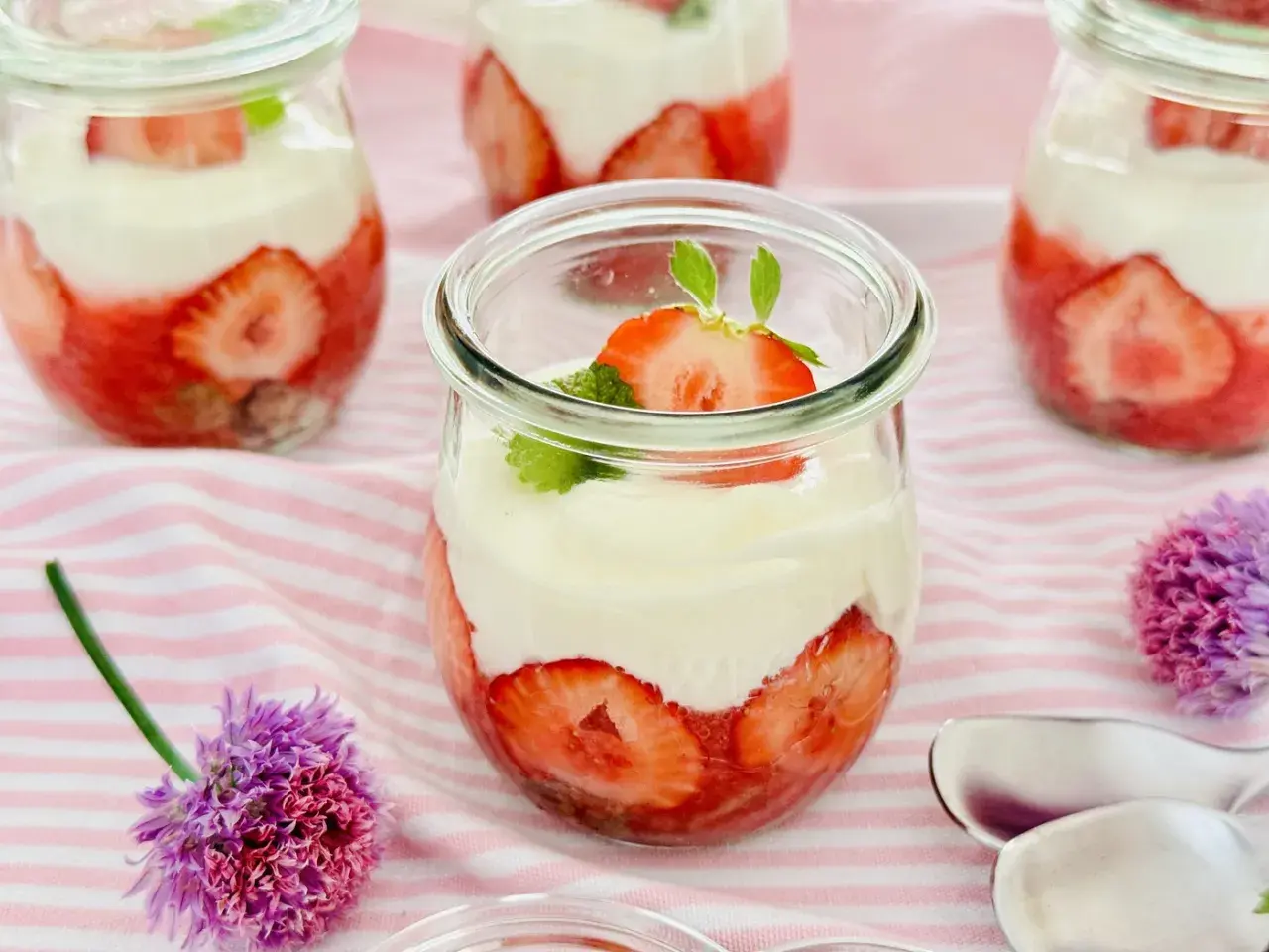 Erdbeer Dessert schnell im Glas geschichtet mit Sahne und frischen Erdbeeren, garniert mit Minze. Perfekt für den Sommer!