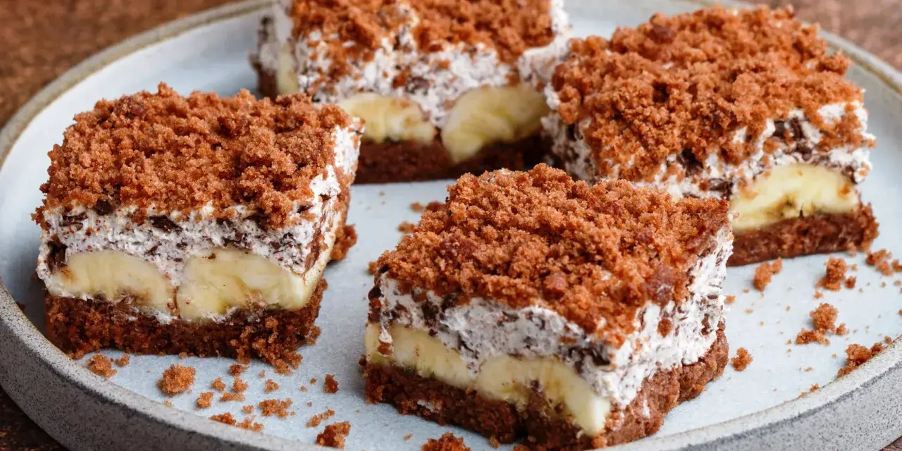Vier Stücke saftiger Maulwurfkuchen vom Blech mit Bananen und Schokoladenstreuseln auf einem Teller.