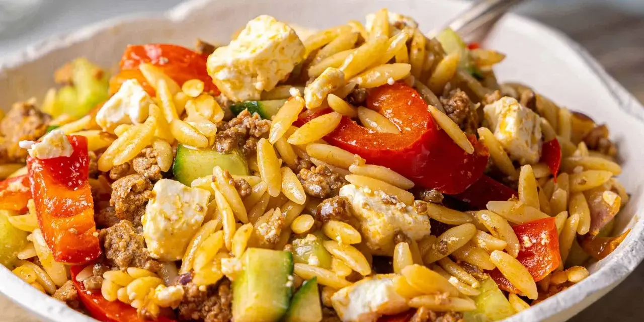 Herzhafter Kritharaki Salat mit Hackfleisch, Feta, Gurke und roten Paprikastücken. Ein köstliches Gericht, das alle Geschmacksnerven verwöhnt.