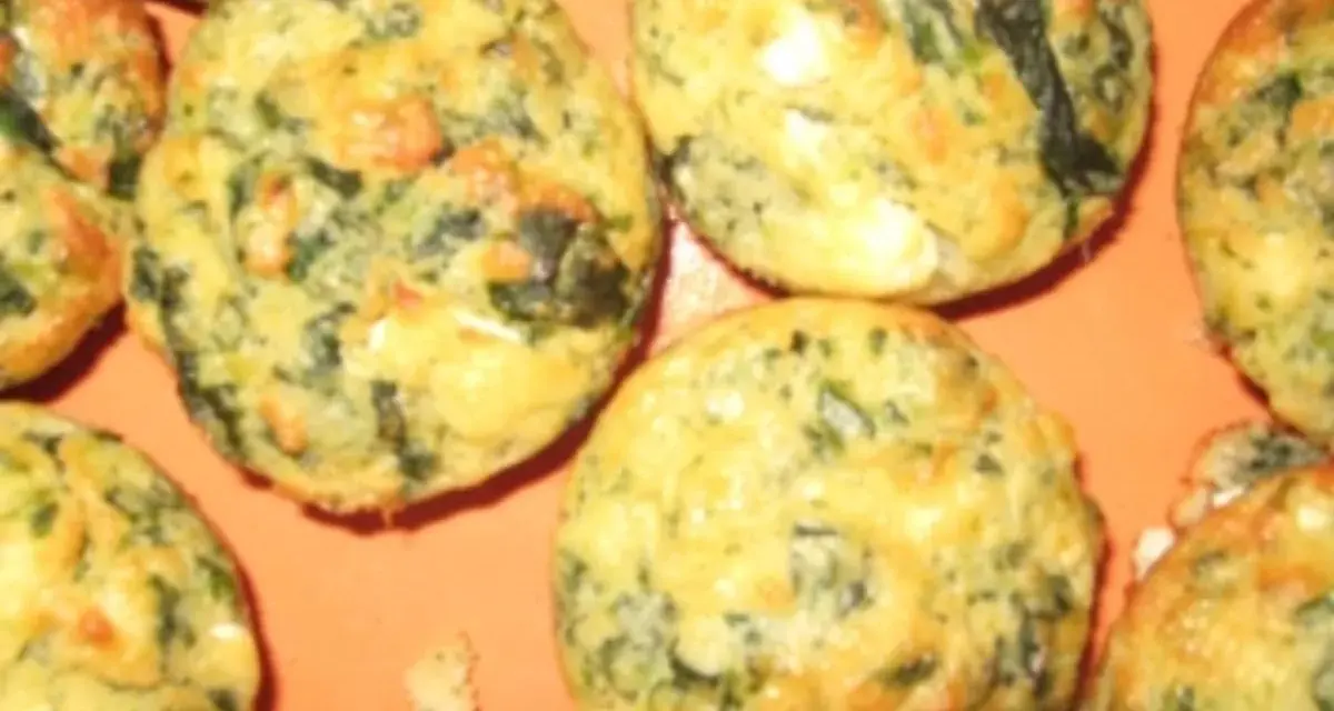 Saftige Spinat Feta Muffins, goldbraun gebacken, mit sichtbaren grünen Spinatstückchen und weißen Feta-Käse-Einlagen.