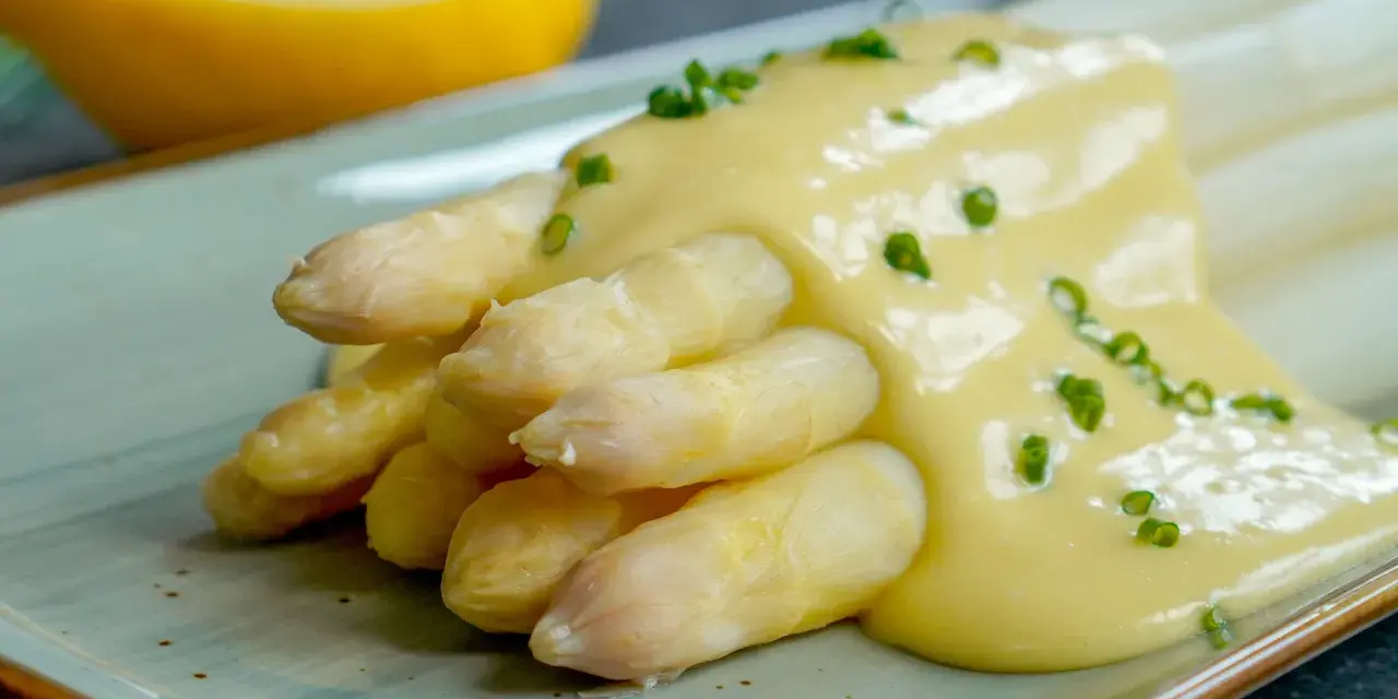 Spargel mit cremiger Sauce Hollandaise, garniert mit Schnittlauch. Ein Klassiker der Frühlingsküche.