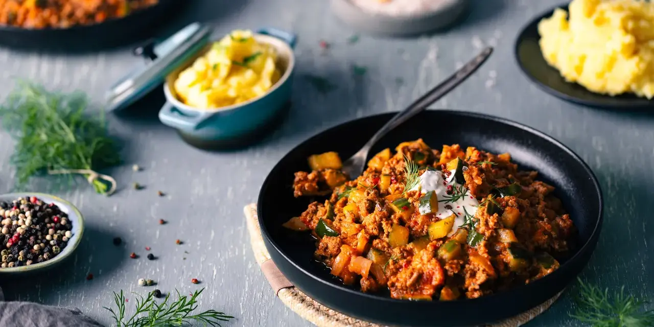 Schmorgurken mit Hack nach Omas Rezept, serviert mit Kartoffelbrei. Ein deftiges Gericht, das Erinnerungen weckt.