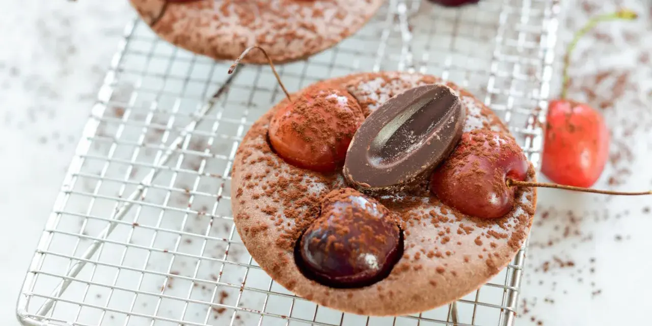 Schokoladen-Clafoutis mit Kirschen und Schokostückchen, ein köstliches clafoutis rezept original, bestäubt mit Kakaopulver.
