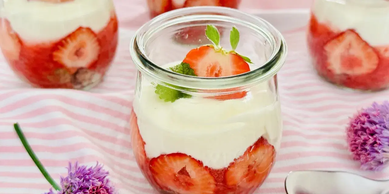 Erdbeer Dessert schnell im Glas geschichtet mit Sahne und frischen Erdbeeren, garniert mit Minze. Perfekt für den Sommer!