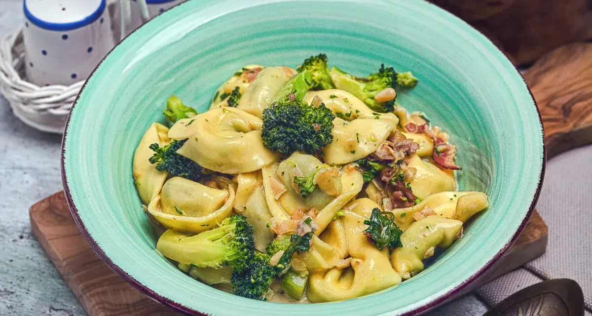 Eine Schüssel mit Tortellini in cremiger Sauce, garniert mit Brokkoli und Speck. Perfekt für eine schnelle Sauce zu Tortellini.