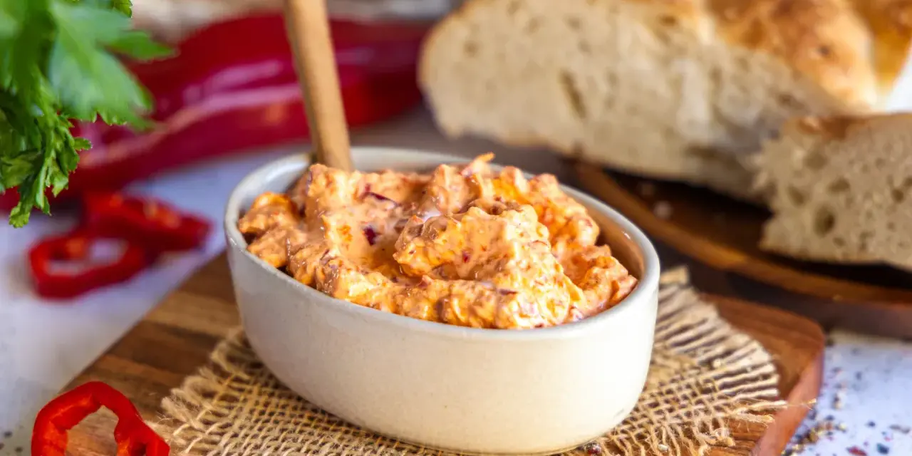 Cremiger Ajvar Feta Dip mit frischer Petersilie und Paprika, serviert mit rustikalem Brot.