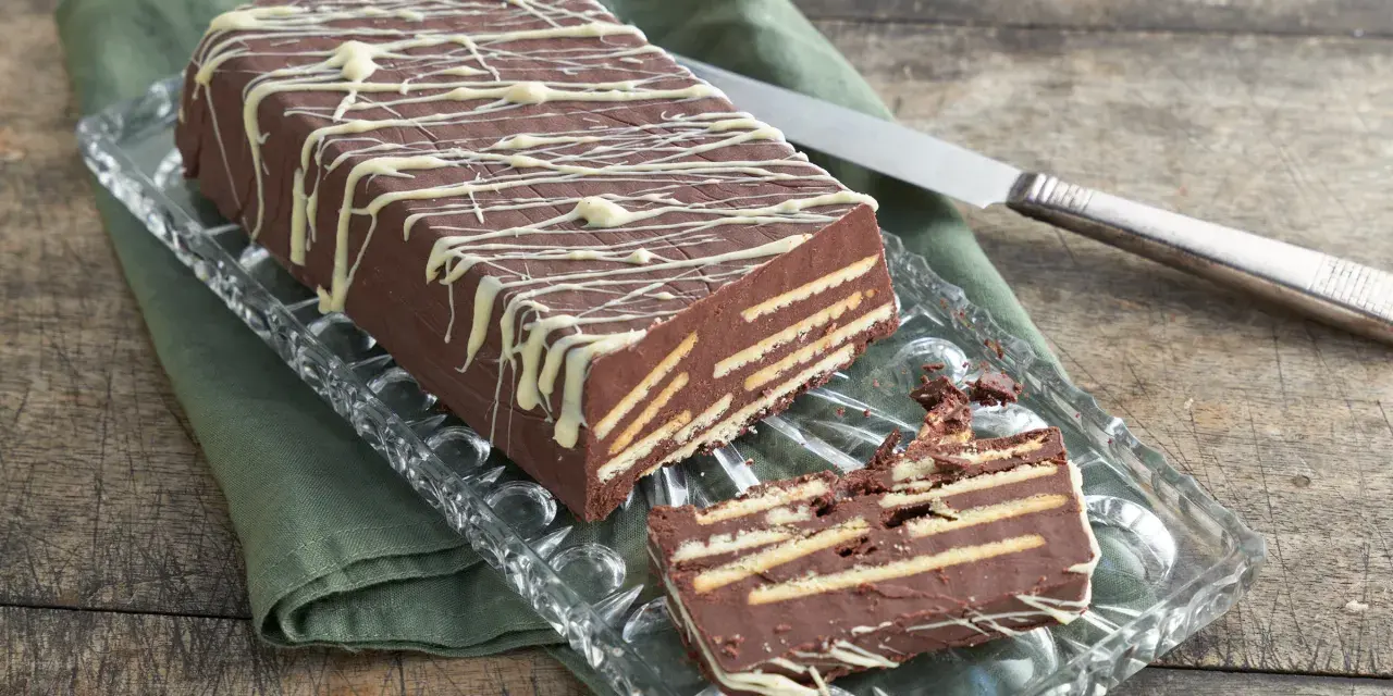 Kalter Hund mit Schokolade und Sahne: Ein Schichtkuchen aus Keksen und Schokomasse, verziert mit weißer Schokolade.