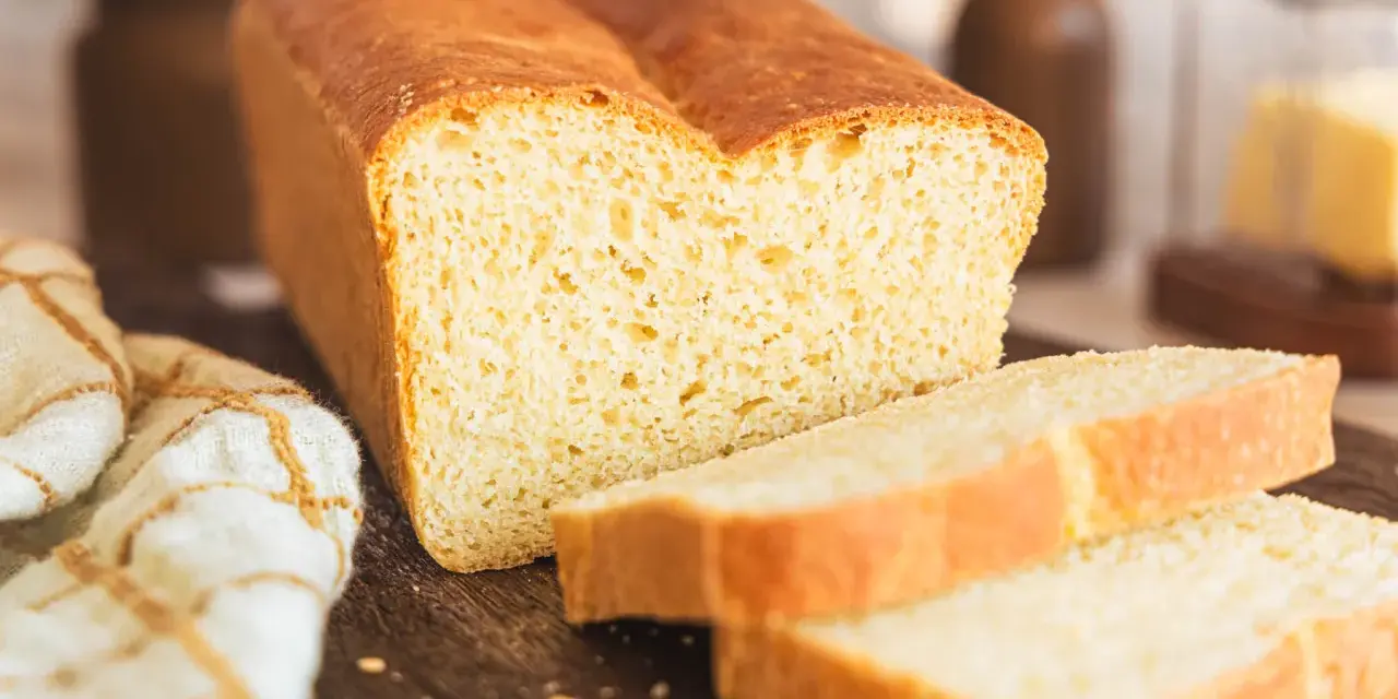 Ein frisch gebackenes, goldbraunes Toastbrot, geschnitten in saftige Scheiben. Das perfekte Ergebnis eines original Toastbrot Rezepts.