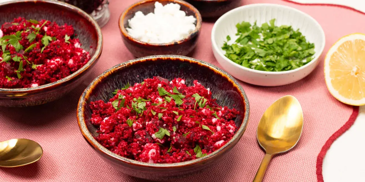 Rote Bete Couscous Salat mit Feta und Petersilie, garniert mit Zitronenspalte.