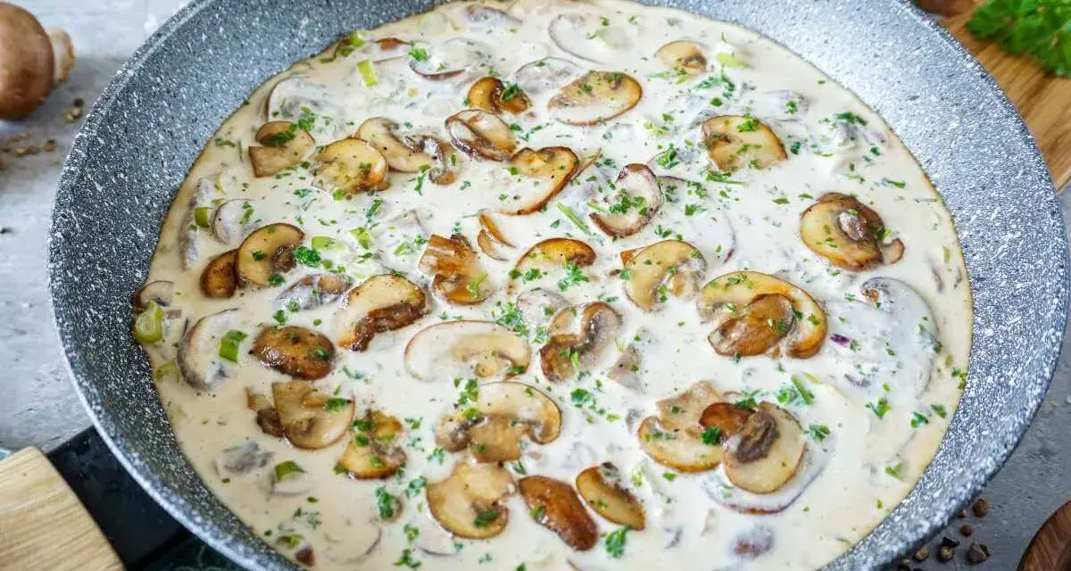 Cremige champignon rahm sauce in einer Pfanne, garniert mit frischer Petersilie. Ein Genuss für jeden Pilzliebhaber!