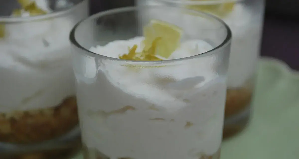 Erfrischendes Limoncello Creme Rezept in Gläsern geschichtet, garniert mit Zitronenspalten.