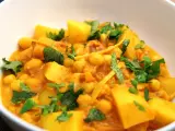 Herzhaftes Kichererbsen Curry mit Kartoffelstücken und frischem Koriander, ein Genuss für die Sinne.