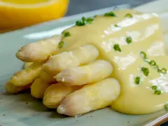 Spargel mit cremiger Sauce Hollandaise, garniert mit Schnittlauch. Ein Klassiker der Frühlingsküche.