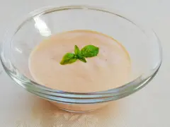 Cremiges Sugo Aurora in einer Glasschale, garniert mit frischem Basilikum.