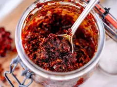 Ein Glas mit würzigem Chili Crunch, perfekt für jedes Chili Crunch Rezept. Eine Löffelspitze voller Geschmack!