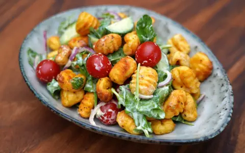 Herzhafter Gnocchi Salat mit Kirschtomaten, Gurken und einem cremigen Dressing.