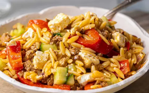 Herzhafter Kritharaki Salat mit Hackfleisch, Feta, Gurke und roten Paprikastücken. Ein köstliches Gericht, das alle Geschmacksnerven verwöhnt.