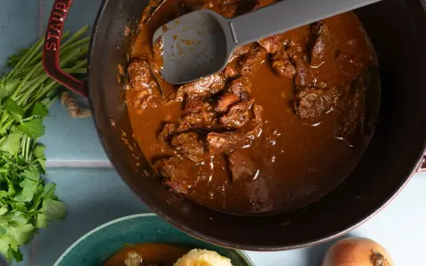 Herzhaftes Gulasch im Gusseisentopf, das beste Gulasch Rezept original Oma. Mit Petersilie und Zwiebeln.