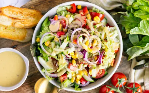 Frischer gemischter Salat mit Tomaten, Gurken, Mais und roten Zwiebeln, perfekt als leichtes Mittagessen. Ein tolles gemischter salat rezept!