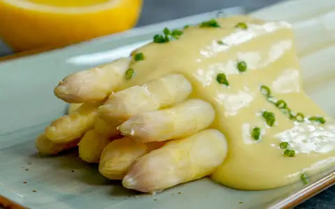 Spargel mit cremiger Sauce Hollandaise, garniert mit Schnittlauch. Ein Klassiker der Frühlingsküche.