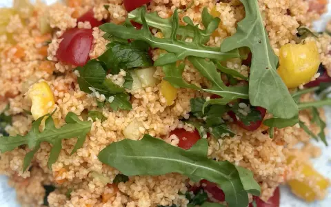 Frischer Couscous-Salat mit Tomaten, Gurken, Paprika und Rucola. Ein leichter und gesunder Genuss.