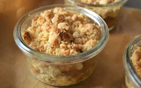 Leckerer Apfel Crumble in einem Glas, goldbraun gebacken, mit knuspriger Streuseldecke.