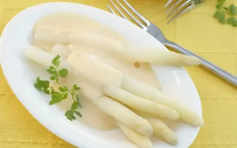 Spargel mit cremiger sauce hollandaise ohne ei, garniert mit Petersilie. Ein Genuss für jeden Gaumen.