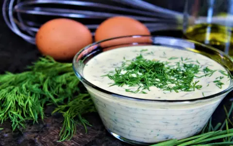 Schüssel mit cremiger Remoulade, garniert mit Dill. Eier und Kräuter deuten auf ein authentisches Remoulade Rezept Original hin.