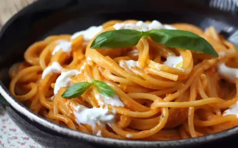 Spaghetti mit cremiger Tomatensoße und frischer Burrata, garniert mit Basilikum. Ein Genuss für alle Liebhaber von Pasta.