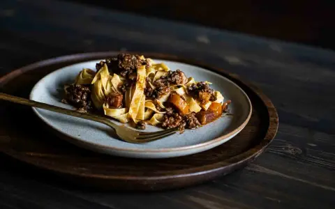 Teller mit breiten Bandnudeln und herzhafter Hackfleischsauce, eine köstliche spaghetti bolognese.