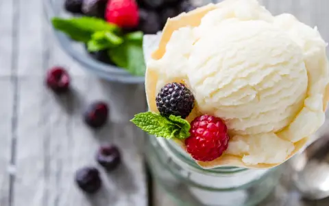 Cremiges Joghurteis selber machen, garniert mit frischen Beeren und Minze. Ein Genuss für heiße Tage!