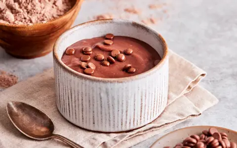 Schokoladenpudding, frisch zubereitet, mit Schokostückchen garniert. Perfekt, um Pudding selber machen zu lernen.