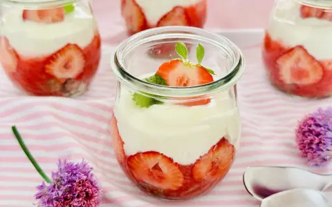 Erdbeer Dessert schnell im Glas geschichtet mit Sahne und frischen Erdbeeren, garniert mit Minze. Perfekt für den Sommer!